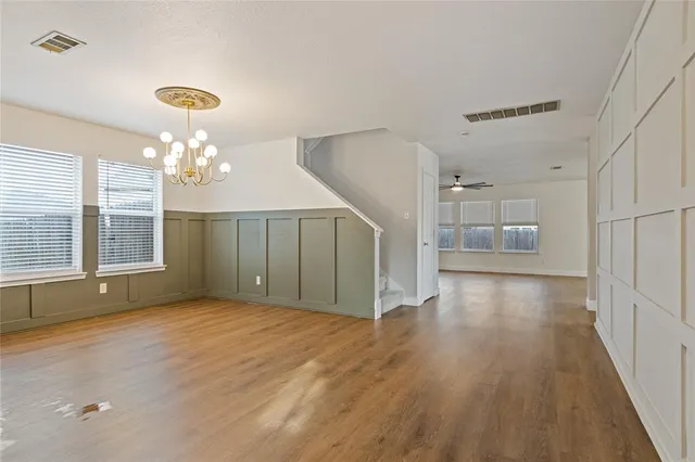 a view of an empty room with window and wooden floor