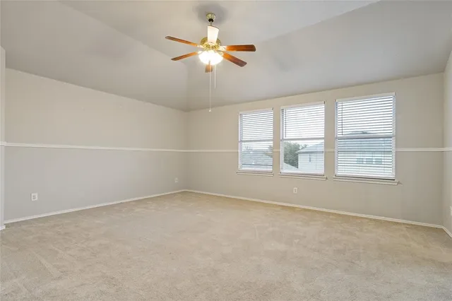 an empty room with a window and a fan
