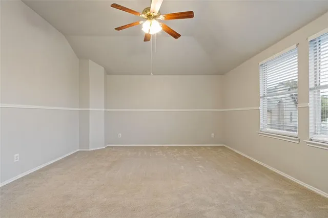 an empty room with a window and a fan