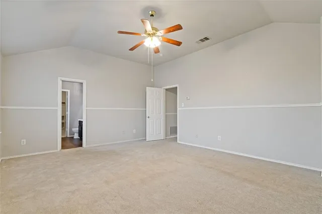 an empty room with closet and a ceiling fan