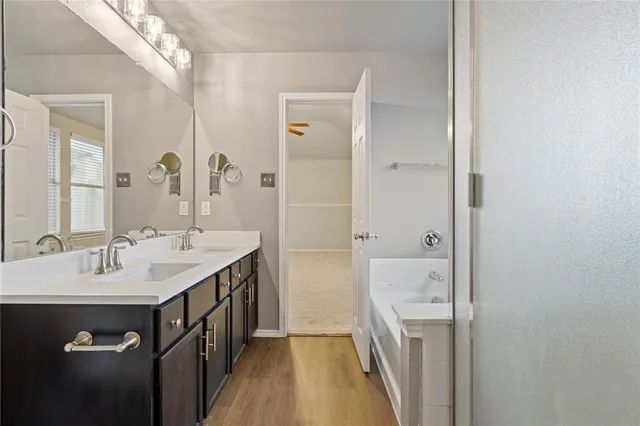 a spacious bathroom with a double vanity sink a mirror and a shower