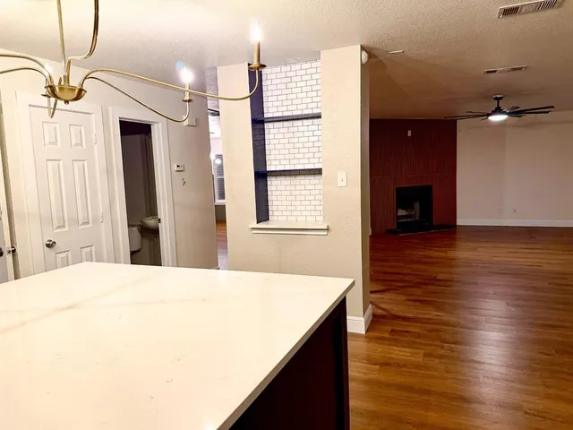 a view of a hallway with wooden floor and staircase