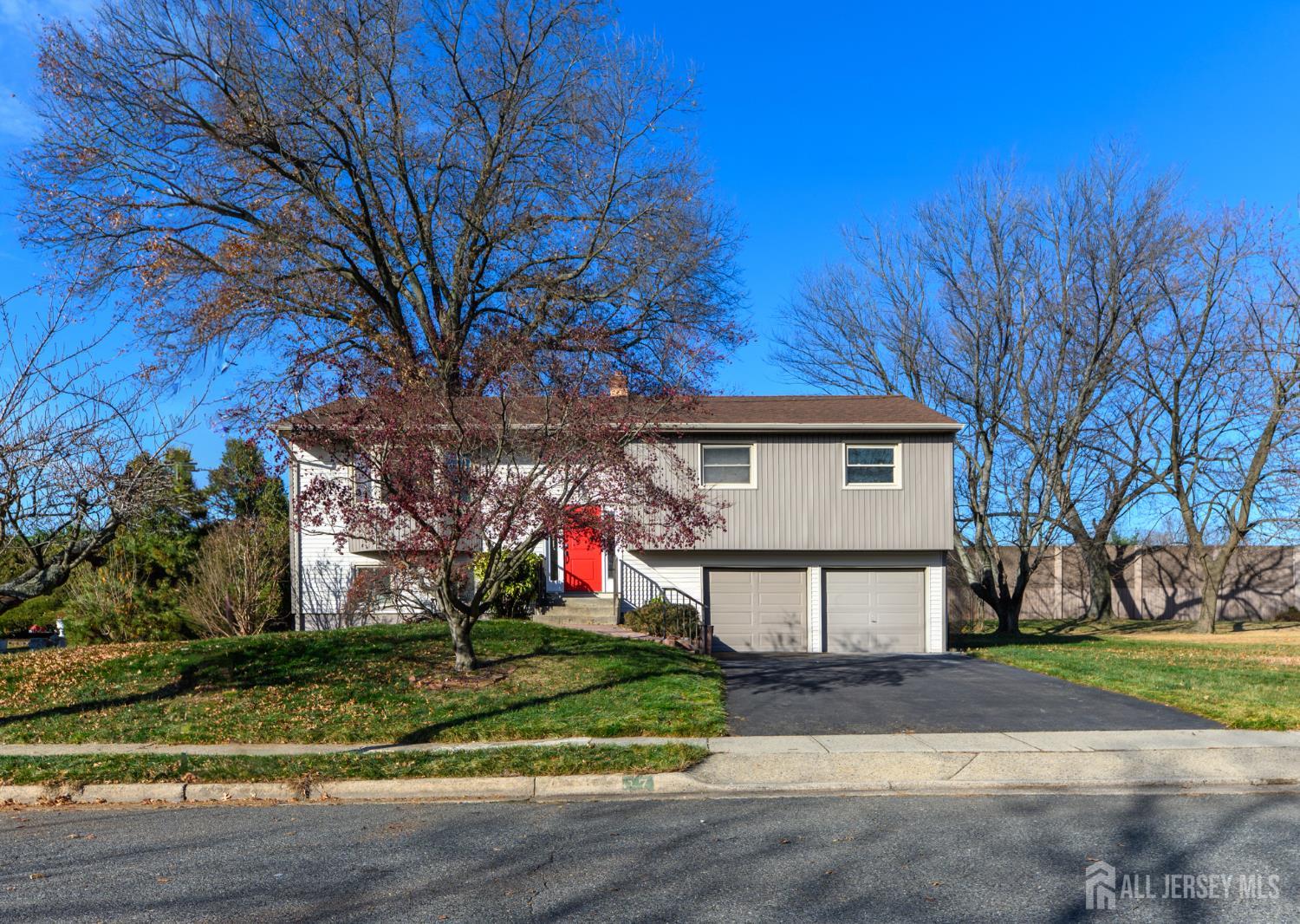 17 Wellington Road East Brunswick, NJ 08816 - Photo 2 of 23 a front view of a house with a yard and garage