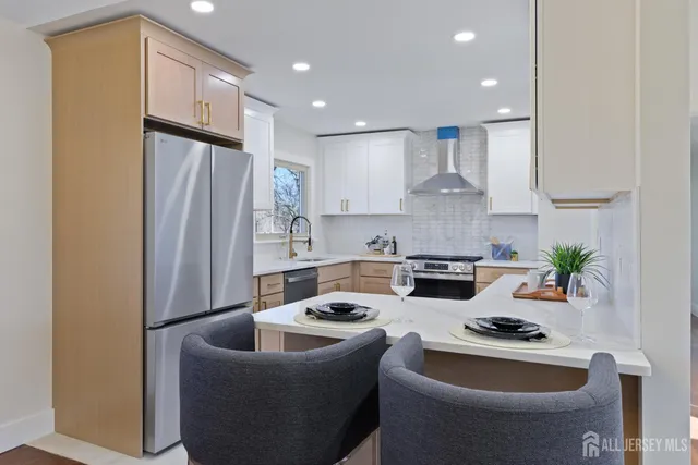 a kitchen with stainless steel appliances granite countertop a refrigerator a sink a stove and white cabinets