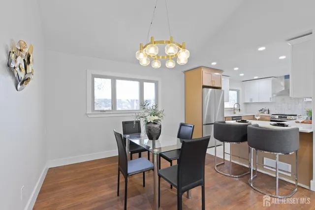 a view of a dining room with furniture a chandelier and wooden floor