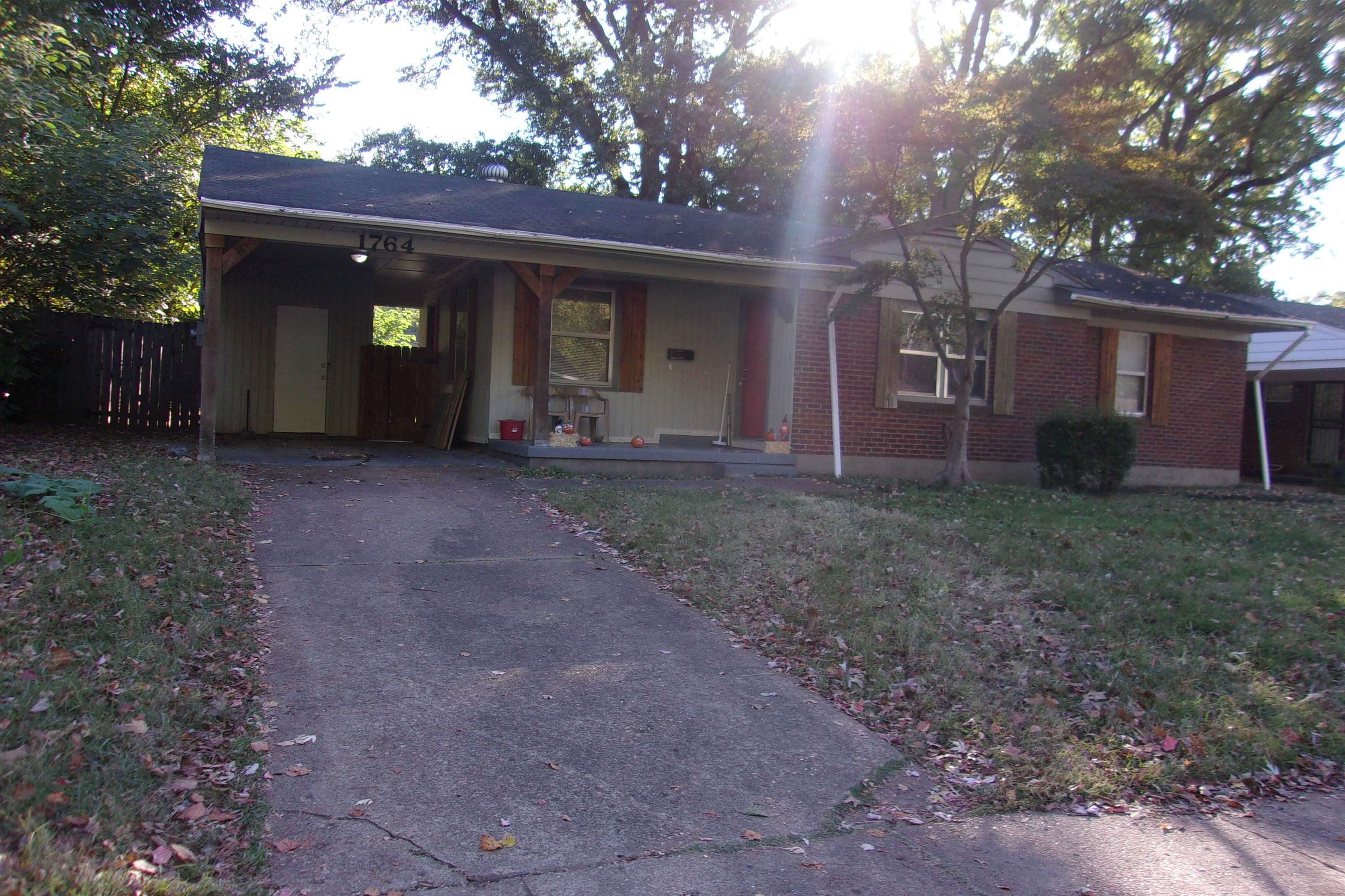 a view of a house with a yard and a large tree