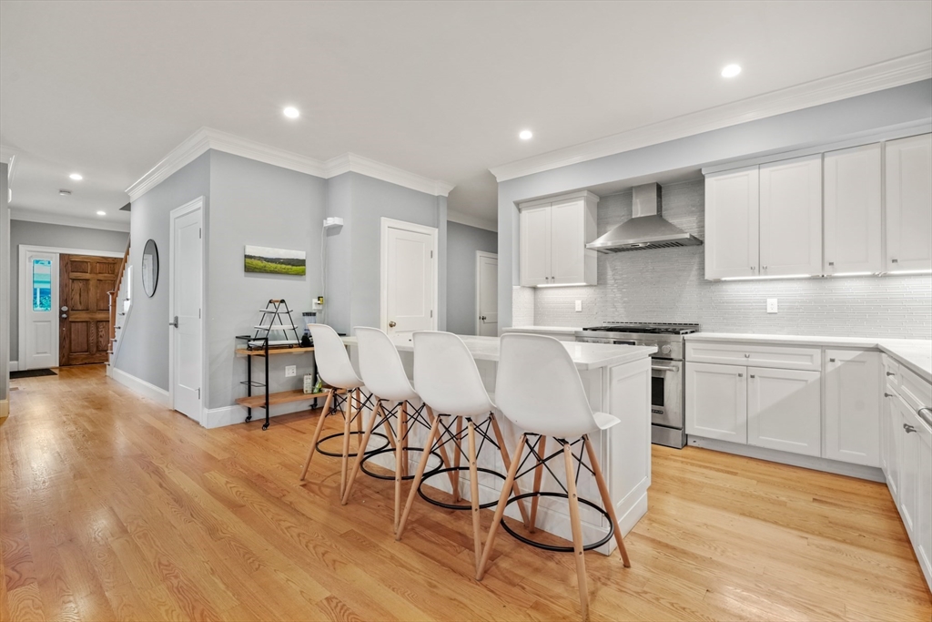 26 Brookfield Road Waltham, MA 02452 - Photo 11 of 37 a kitchen with stainless steel appliances kitchen island granite countertop a table chairs sink and cabinets