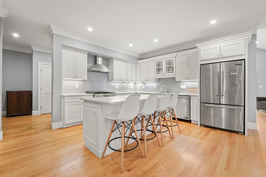 26 Brookfield Road Waltham, MA 02452 - Photo 8 of 37 a kitchen with stainless steel appliances granite countertop a refrigerator stove top oven and a sink with wooden floor