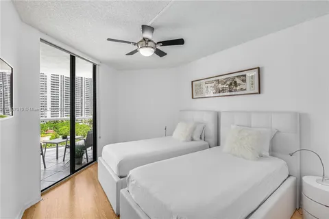 a spacious bedroom with a bed and a chandelier