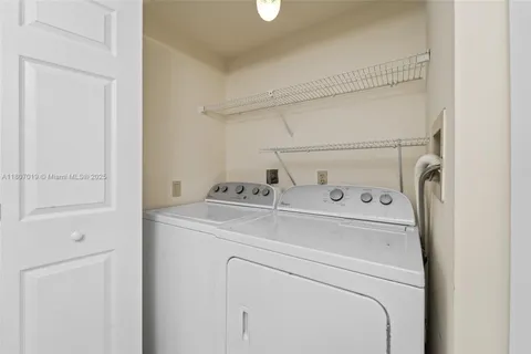 a bedroom with a bed a dresser and a chandelier