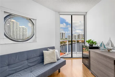 a bedroom with a bed flat screen tv and couches