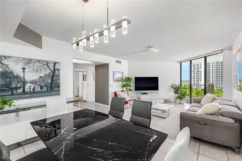 a living room with furniture a flat screen tv and a large window