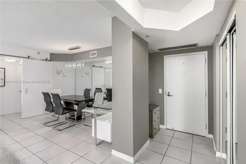 a view of a dining room with furniture a livingroom and chandelier