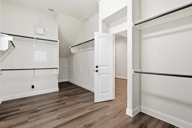 a view of walk in closet with wooden floor