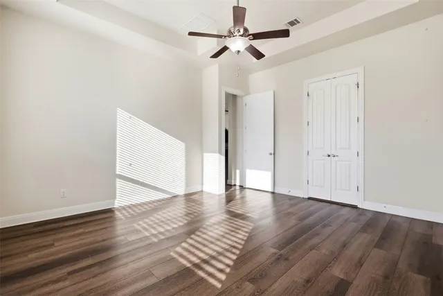 a view of an empty room with wooden floor