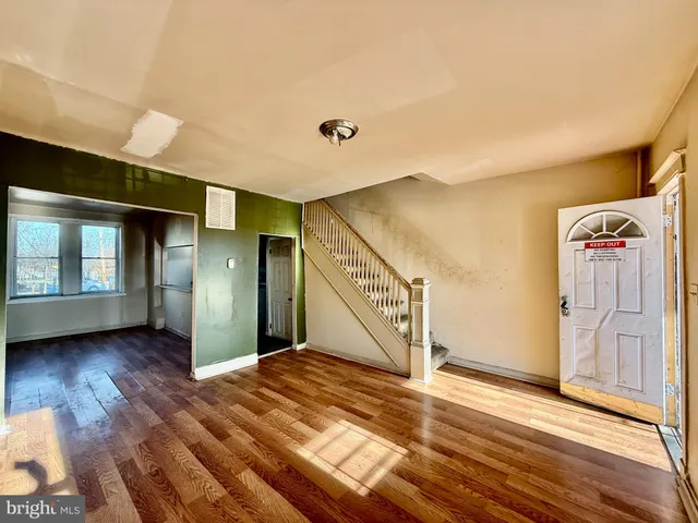 a view of a hallway with wooden floor and stairs