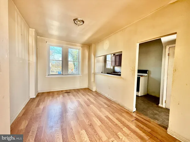a view of empty room with wooden floor and window