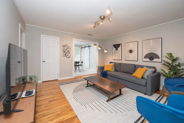 a living room with furniture and wooden floor