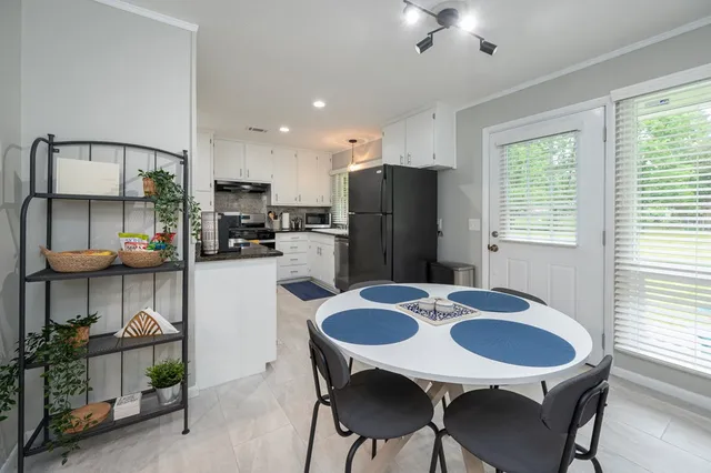 a kitchen with refrigerator and chairs