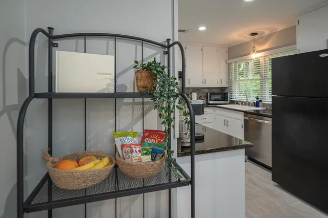 a kitchen with stainless steel appliances granite countertop a sink refrigerator and microwave