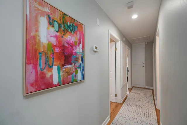 a view of a hallway with painting on the wall