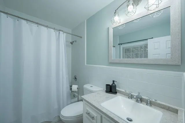 a bathroom with a sink vanity mirror and toilet