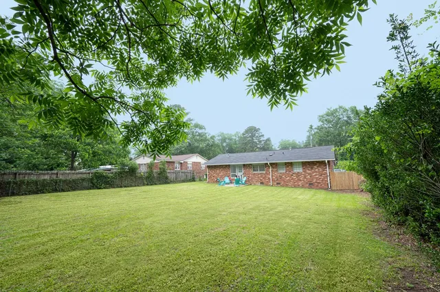 a view of a house with a yard and a patio