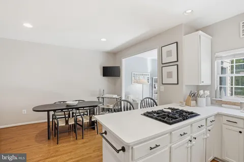 a kitchen with a stove a table and chairs in it