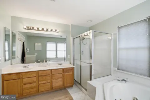 a bathroom with a tub sink shower and mirror