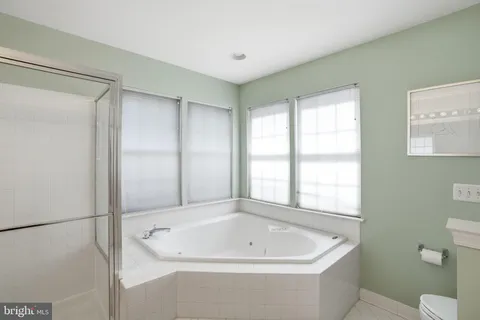 a white bath tub sitting next to a toilet