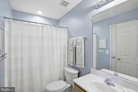 a bathroom with a toilet sink and shower curtain