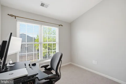 a view of a workspace with furniture and a window