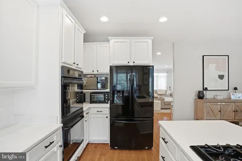 a kitchen with a refrigerator and a stove top oven