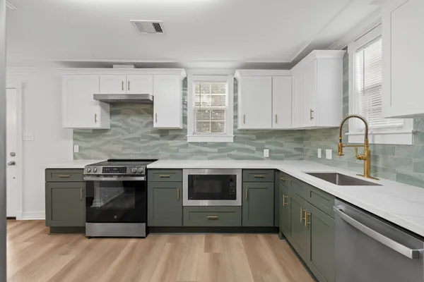 a kitchen with stainless steel appliances granite countertop a stove and a sink
