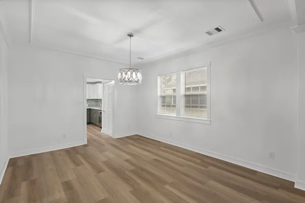 a view of empty room with wooden floor and ceiling fan