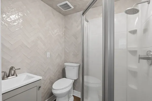 a bathroom with a toilet sink vanity and shower