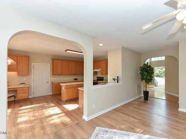 a view of a room with wooden floor and a ceiling fan