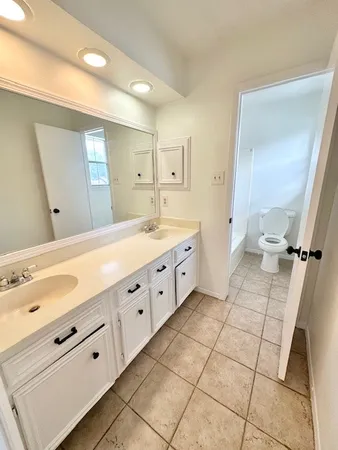 a spacious bathroom with a double vanity sink mirror and toilet