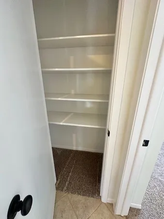 a view of walk in closet with empty racks