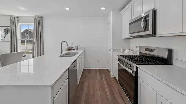 a kitchen that has a microwave a stove and a sink