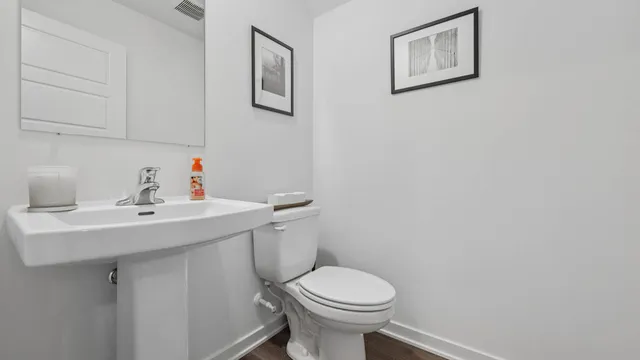 a bathroom with a sink toilet and a mirror