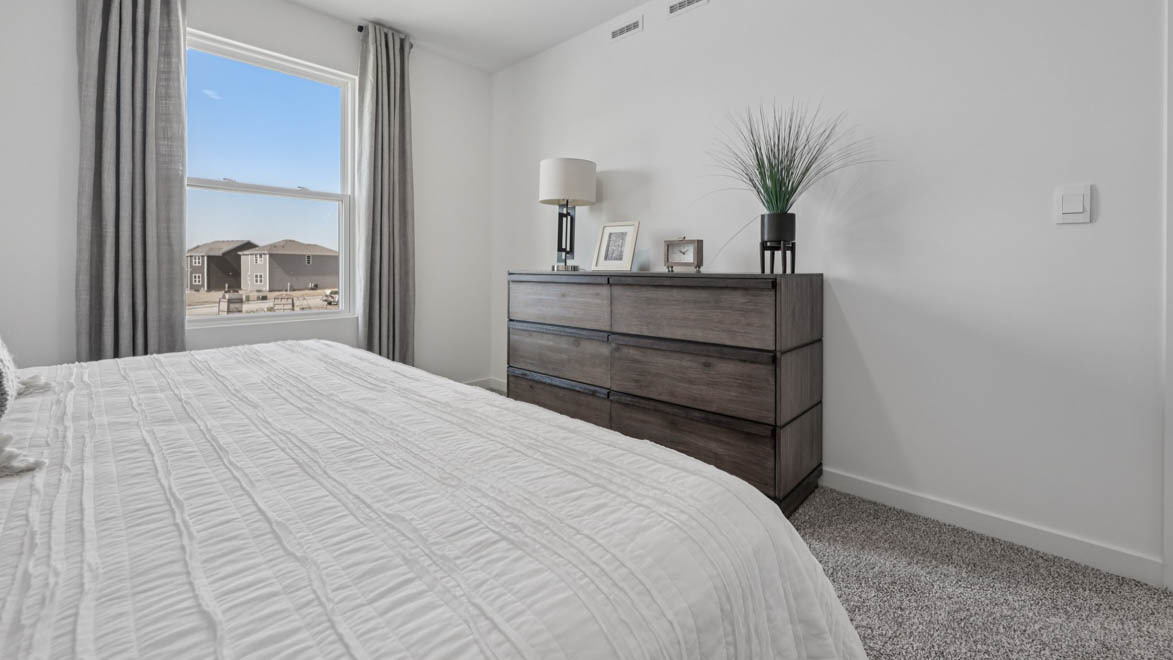 7105 Fair Oaks Road, Unit 38 Racine, WI 53403 - Photo 22 of 30 a bedroom with a bed and a potted plant on the dresser