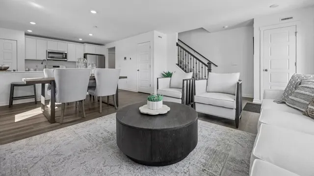 a living room with furniture and a dining table with kitchen view