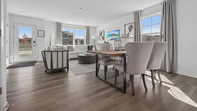 a living room with furniture a large window and wooden floor