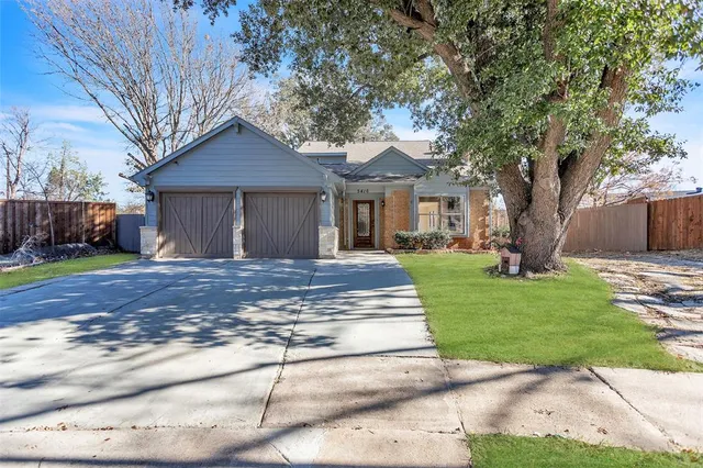 a front view of a house with a yard and trees