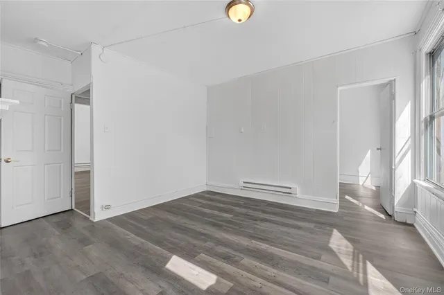 a view of empty room with wooden floor