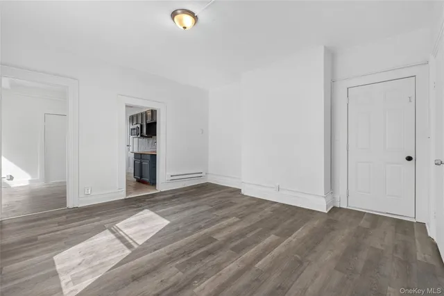 an empty room with wooden floor and closet
