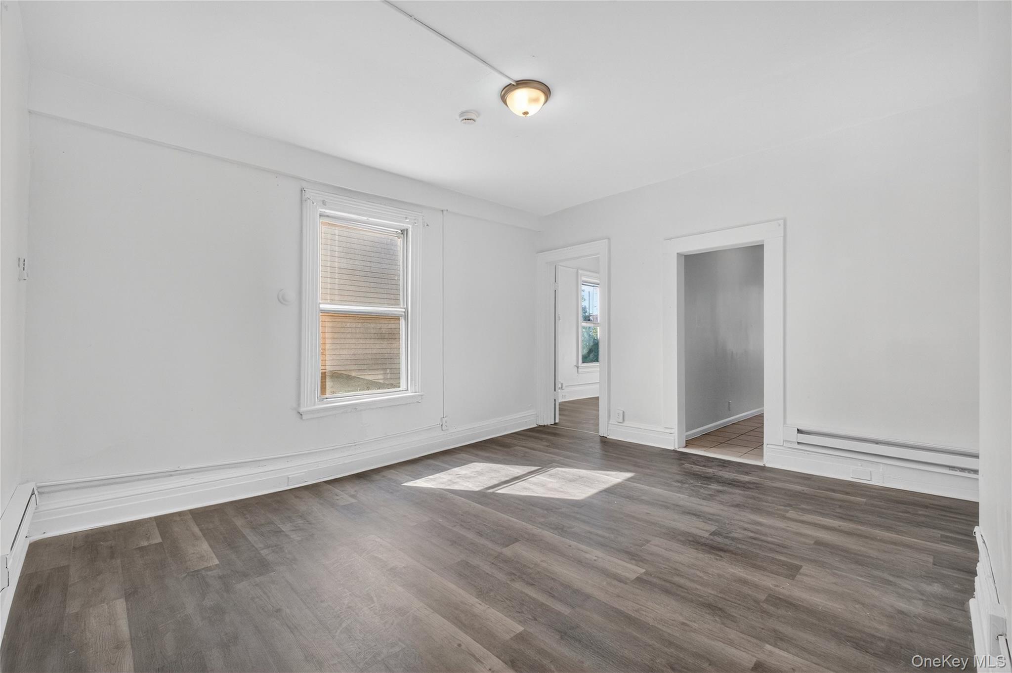 49 South Hamilton Street, Unit 2 Poughkeepsie, NY 12601 - Photo 5 of 27 an empty room with wooden floor and windows