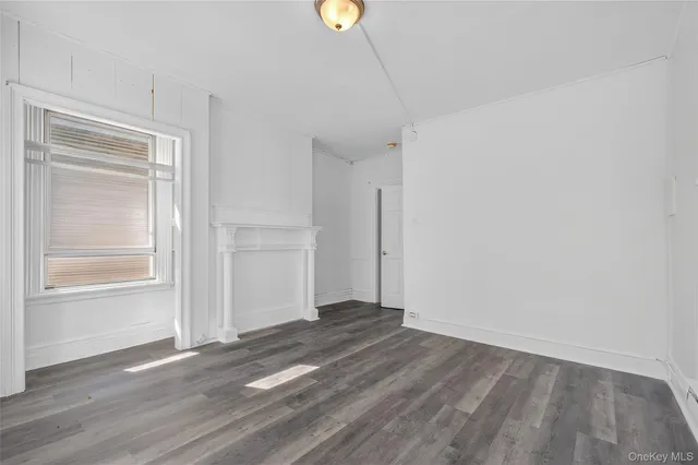 a view of a room with wooden floor and window