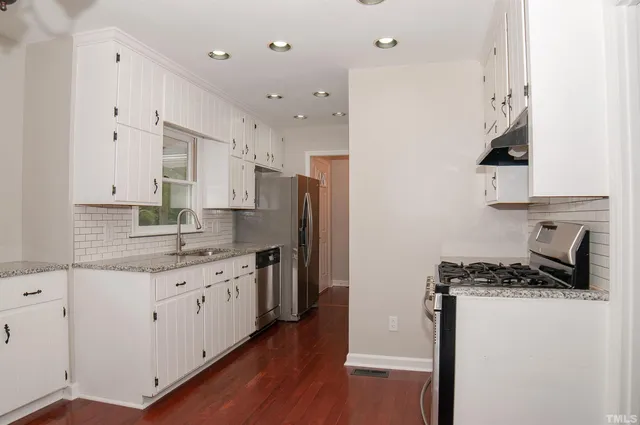 an empty room with wooden floor and mirror